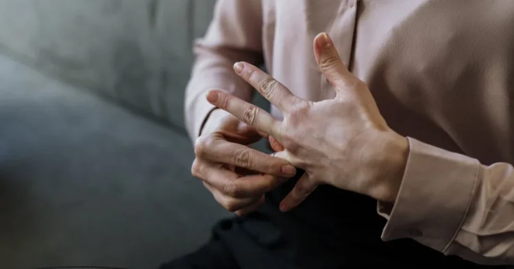 perempuan sedang melepas cincin pernikahan