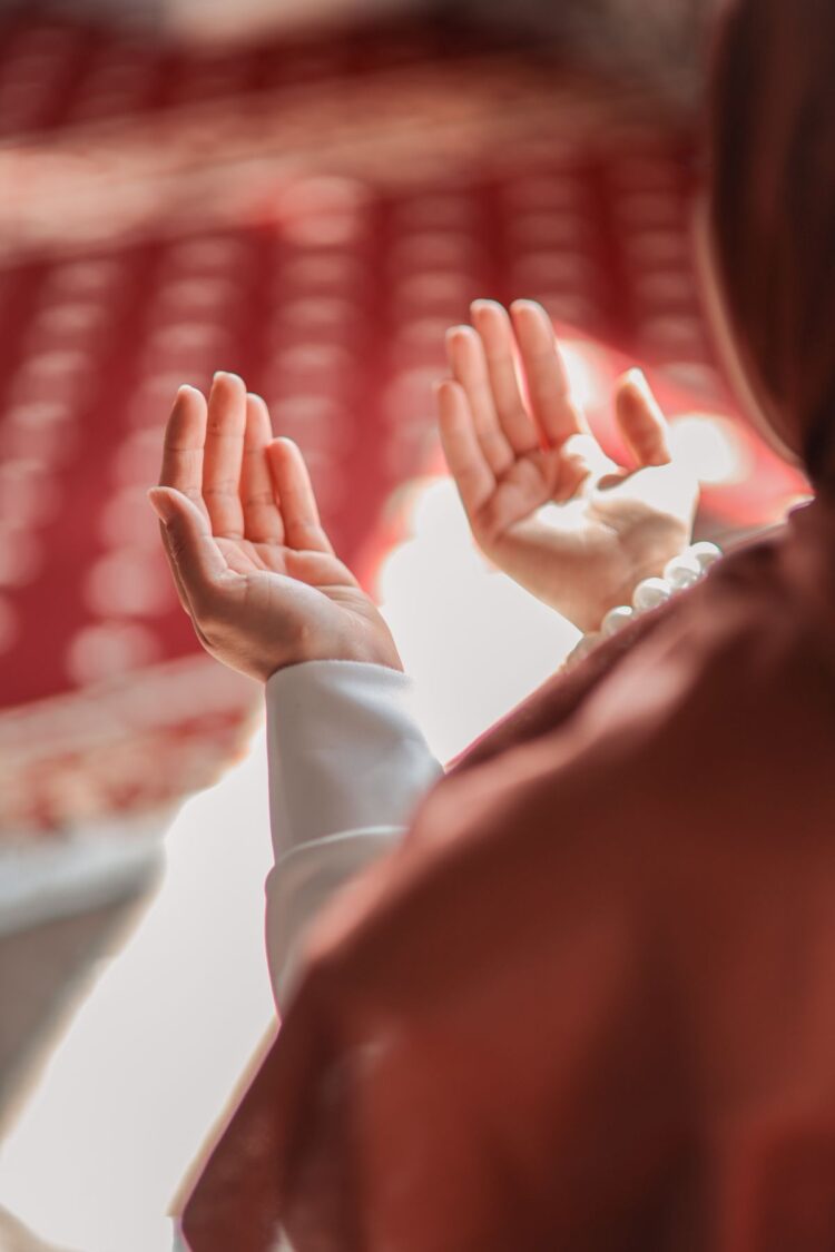 Tangan terbuka berdoa di dalam masjid, ilustrasi hukum dan lafaz doa iftitah dalam shalat