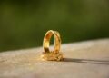 Dua cincin emas di atas permukaan batu, ilustrasi hukum gadai (rahn) dan pinjaman darurat dalam Islam