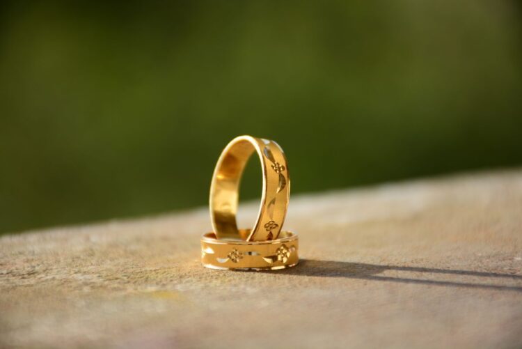 Dua cincin emas di atas permukaan batu, ilustrasi hukum gadai (rahn) dan pinjaman darurat dalam Islam