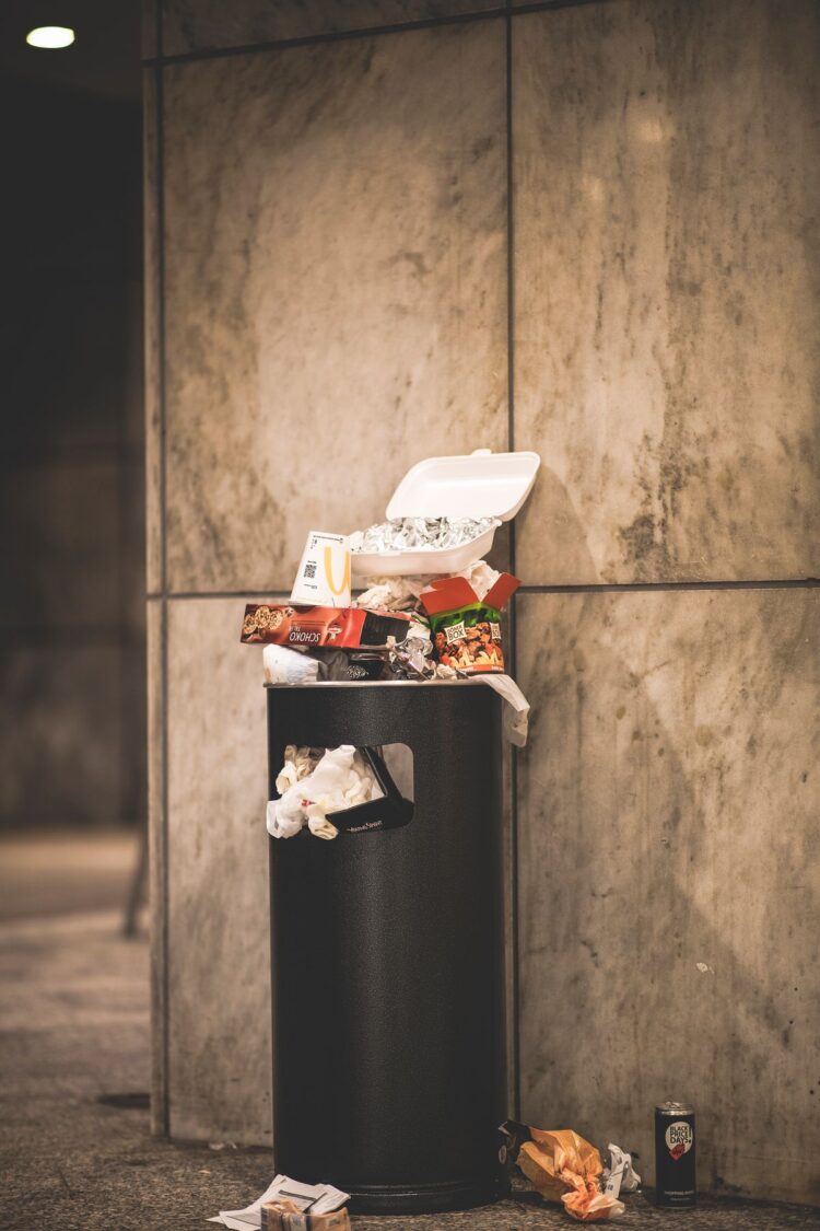 Tempat sampah meluap berisi sisa makanan dan kemasan, ilustrasi hadits tentang larangan israf dan mubazir