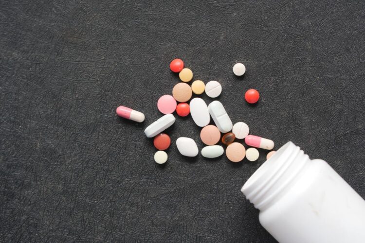 Aneka pil dan kapsul obat tertumpah dari botol, ilustrasi hadits tentang narkoba dalam Islam