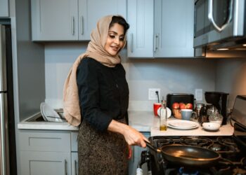 Istri muslimah memasak di dapur, ilustrasi hak dan kewajiban istri dalam rumah tangga