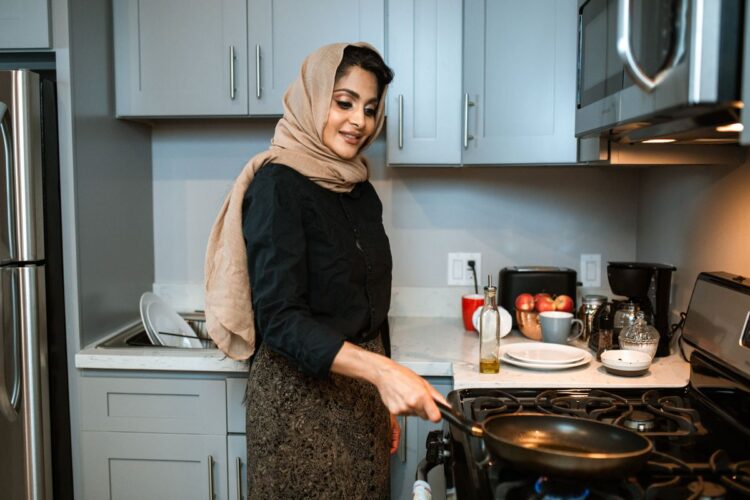 Istri muslimah memasak di dapur, ilustrasi hak dan kewajiban istri dalam rumah tangga