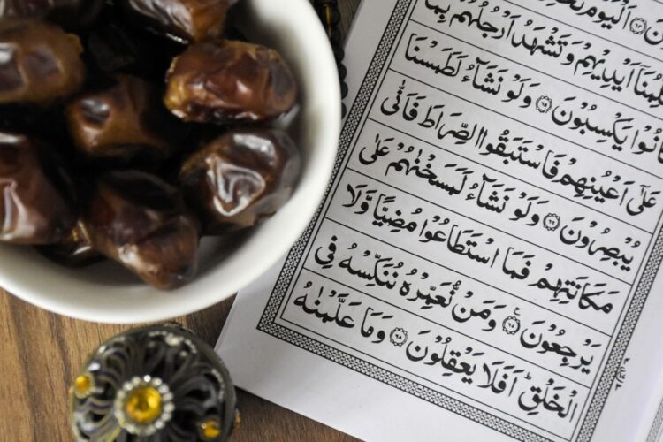 Semangkuk kurma di samping mushaf Al-Quran, ilustrasi puasa Ramadan