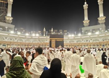 Jamaah berkumpul mengelilingi Kakbah di Masjidil Haram pada malam hari, ilustrasi keutamaan Surat Al-Fath