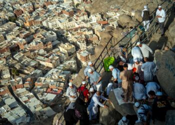 Jamaah haji menaiki tangga batu di Jabal Rahmah, Arafah, ilustrasi keutamaan puasa Arafah