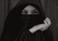 Wanita mengenakan cadar hitam menutup wajah, ilustrasi pembahasan hukum cadar dalam Islam
