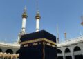 Jamaah haji berpakaian ihram putih menghadap Ka'bah di siang hari, ilustrasi keutamaan haji mabrur