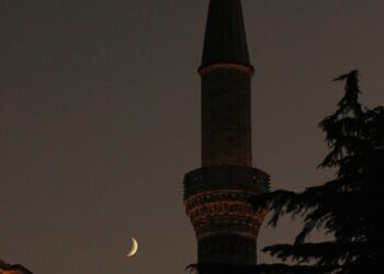 Menara masjid dengan bulan sabit di langit malam, ilustrasi peristiwa Isra Mi'raj Rasulullah shallallahu alaihi wasallam