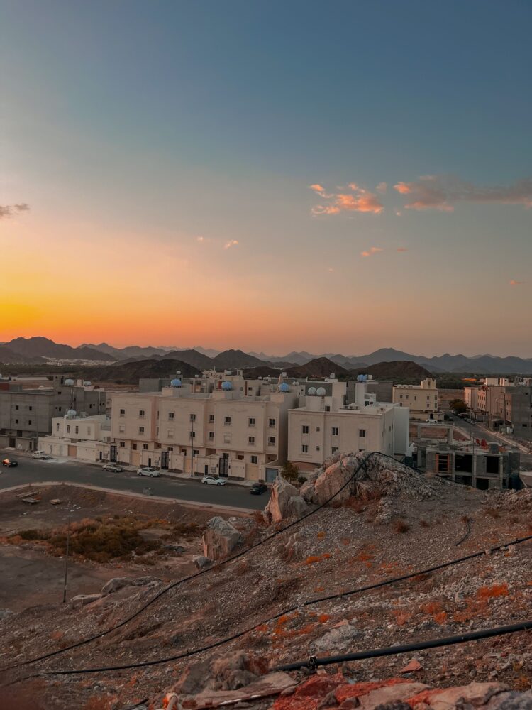 Pemandangan kota Madinah dengan latar pegunungan saat senja, ilustrasi keutamaan kota Madinah sebagai tanah haram