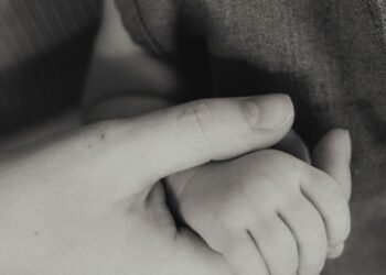 Tangan ibu menggenggam lembut tangan bayi yang baru lahir, ilustrasi keutamaan Surat Maryam