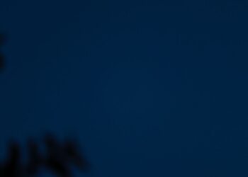 Bulan sabit bersinar di langit malam biru gelap, ilustrasi keutamaan bulan Muharram sebagai bulan Allah