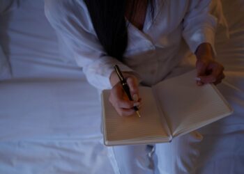 Seseorang menulis di buku catatan dengan tenang, ilustrasi klarifikasi jujur seputar keutamaan bulan Rajab
