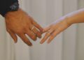 Tangan pasangan suami istri saling meraih mengenakan cincin, ilustrasi keutamaan bulan Syawal dan kisah pernikahan Rasulullah
