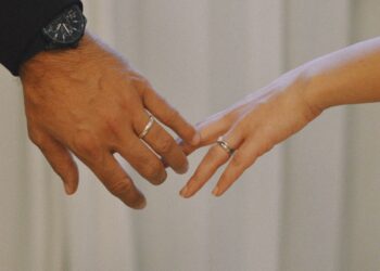 Tangan pasangan suami istri saling meraih mengenakan cincin, ilustrasi keutamaan bulan Syawal dan kisah pernikahan Rasulullah