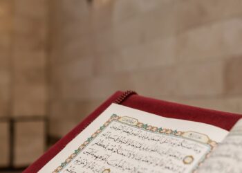 Mushaf Al-Qur'an terbuka di dalam masjid dengan lampu temaram, ilustrasi klarifikasi hadits keutamaan Surat Yasin