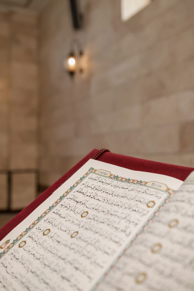 Mushaf Al-Qur'an terbuka di dalam masjid dengan lampu temaram, ilustrasi klarifikasi hadits keutamaan Surat Yasin