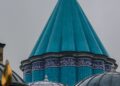 Kubah hijau toska bertuliskan kaligrafi Arab pada makam bersejarah, ilustrasi pembahasan hukum ziarah ke makam wali