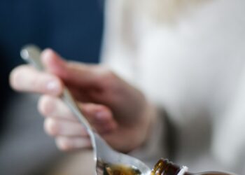 Tangan menuangkan obat batuk sirup ke sendok, ilustrasi hukum obat dan vaksin saat puasa