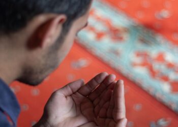 Muslim berdoa setelah shalat rawatib di atas sajadah masjid