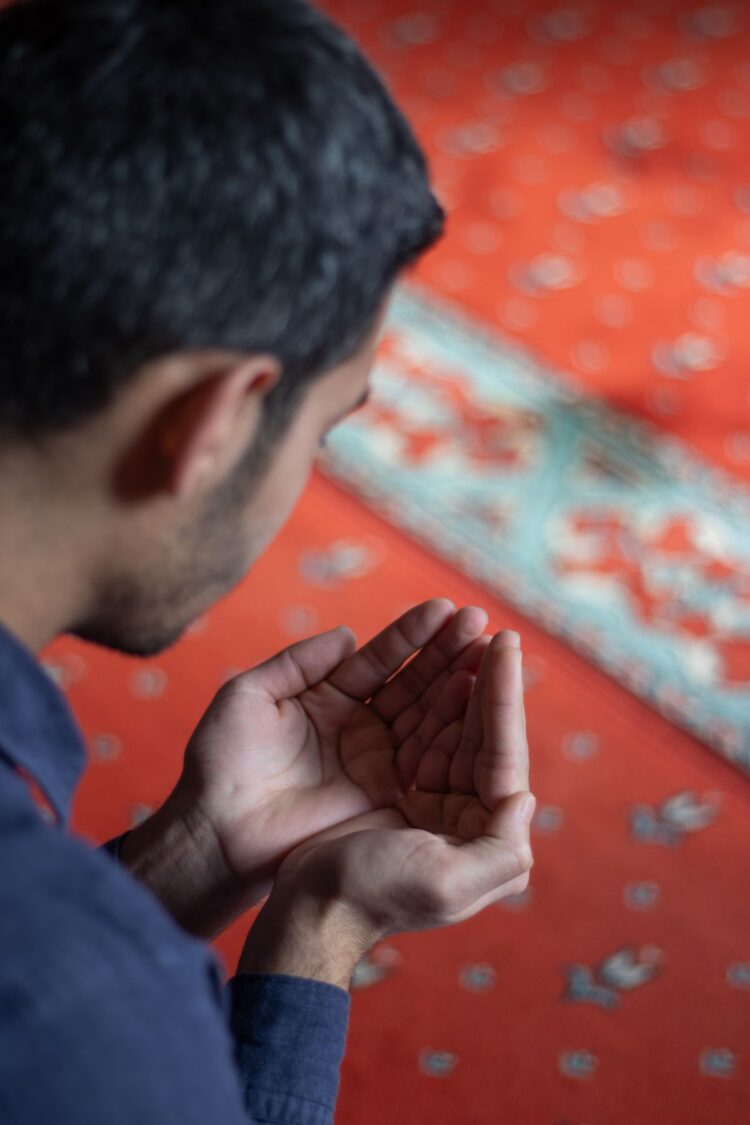 Muslim berdoa setelah shalat rawatib di atas sajadah masjid