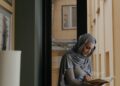 Wanita muslimah berhijab duduk membaca, ilustrasi hukum wanita haid