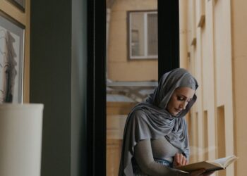Wanita muslimah berhijab duduk membaca, ilustrasi hukum wanita haid
