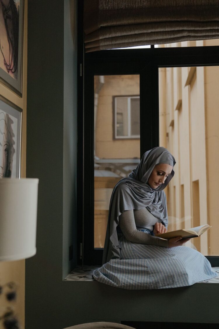 Wanita muslimah berhijab duduk membaca, ilustrasi hukum wanita haid