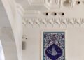 Tiga wanita berjilbab hitam duduk shalat di masjid, ilustrasi hukum wanita ikut shalat Jumat